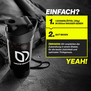 Eine schwarze Shakerflasche mit dem "natural elements"-Logo steht auf einer Fläche; daneben steht eine Mischanleitung für ein Nahrungsergänzungsmittel in deutscher Sprache.